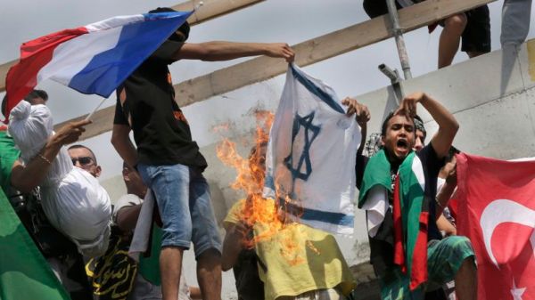 Pro-Palestinian protesters burn an Israeli flag during a demonstration against violence in the Gaza strip in Paris